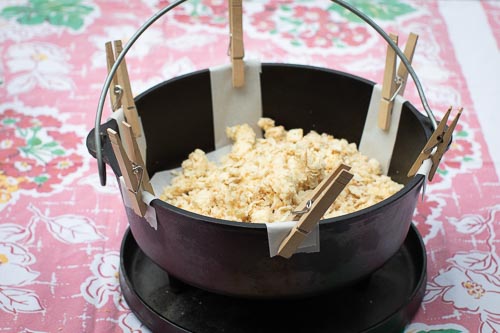 Clothes pins hold parchment paper lift strips in place while pie crust is pushed into bottom of the oven
